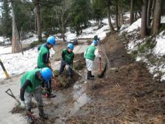 用水路の整備（上流には残雪が：雪で泥に埋もれた水路を毎年復旧しなければならない）