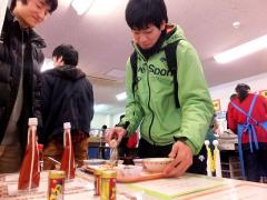 唐辛子調味料をかける学生