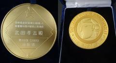 授与されたメダルの表裏（裏は木材学会シンボル）