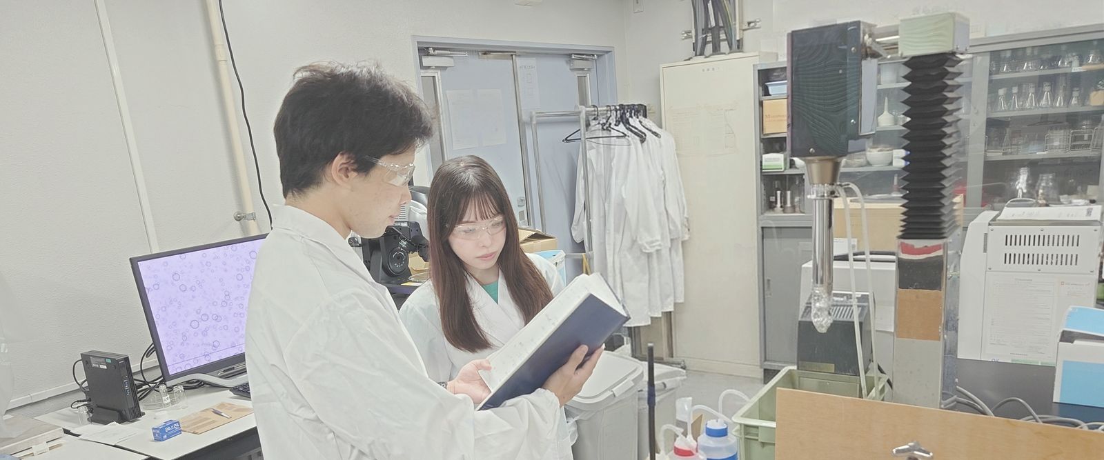 実験ノートを見ながら議論する学生